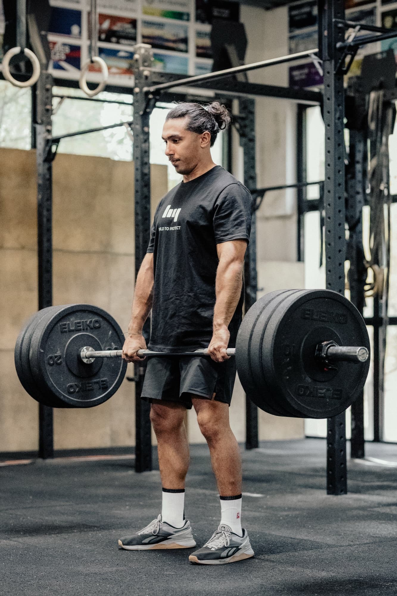 Atleta che prepara un Hang squat clean con bilanciere olimpico.