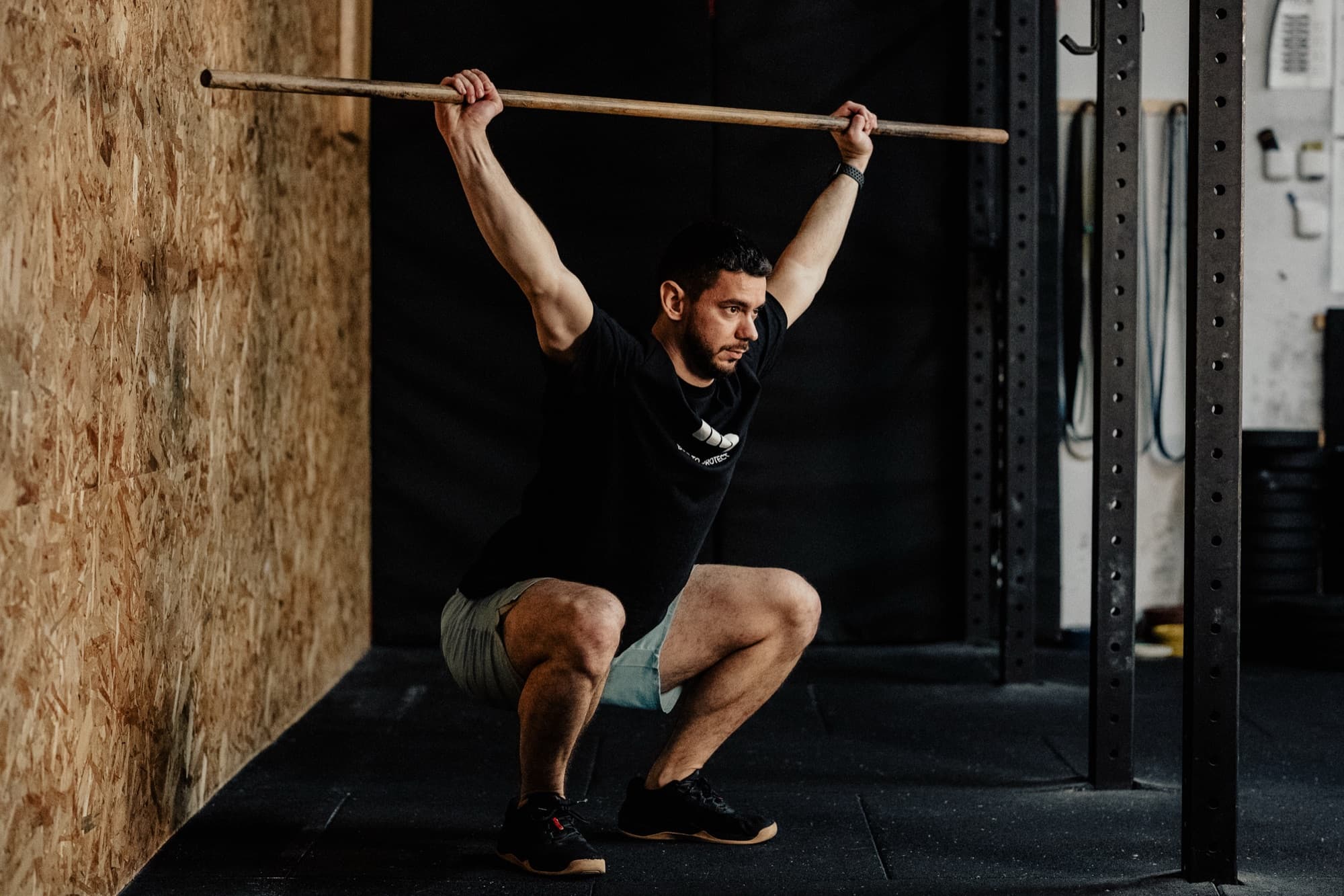 Athlete performing an overhead squat with a stick during the movement test